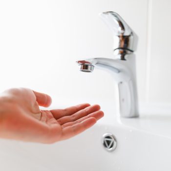 hand under faucet without water